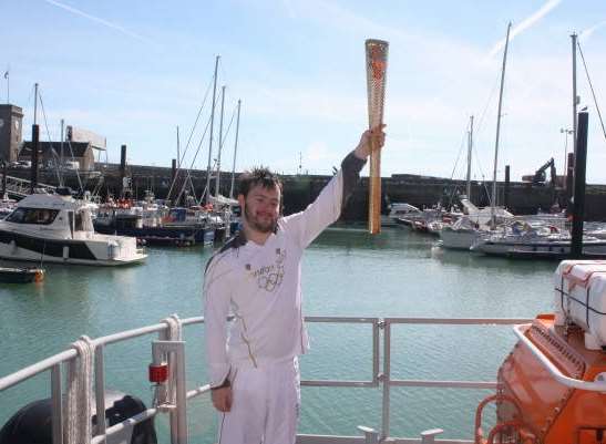 Jamie Clark with the Olympic torch on Dover lifeboat