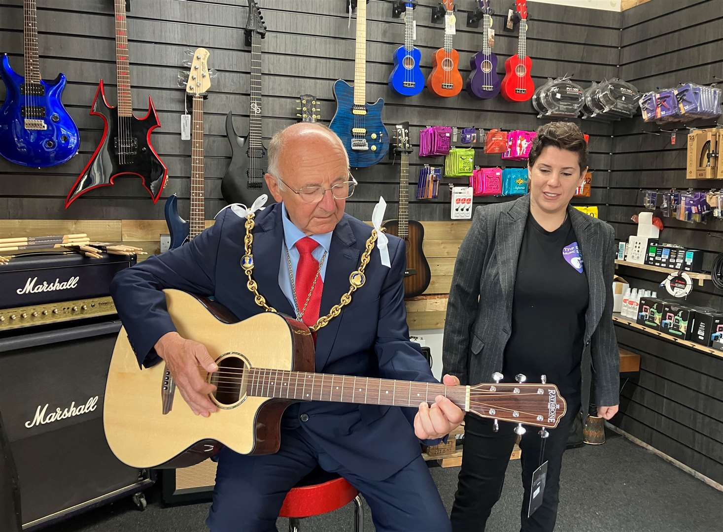 Mayor of Maidstone Gordon Newton has a go at the guitar, under the watchful eye of Rock Music School singing teacher Kate Luck