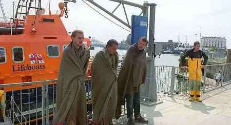 Three asylum seekers after being rescued from a dinghy in the Channel by the Dover lifeboat