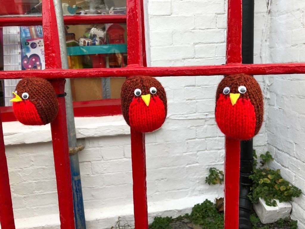 Knitted robins on railing in the town centre