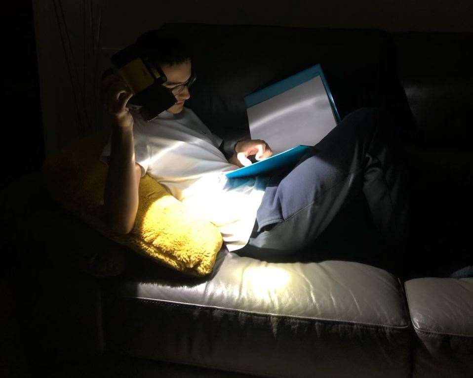 Kelly's son, Kian, doing his homework by torchlight. Photo: Kelly Siadatan