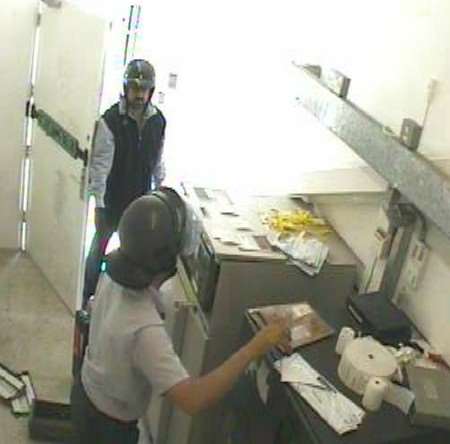 This CCTV picture issued by the police shows the gunman, in the background, and the security guard