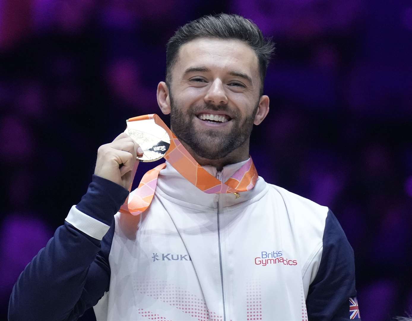 Giarnni Regini-Moran beams after making history at the World Gymnastics Championships with gold in the men's floor. Picture: British Gymnastics/Simone Ferraro