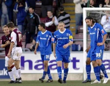 DOWN AND OUT: Gillingham's players hang their heads at Sixfields. Picture: MATTHEW WALKER
