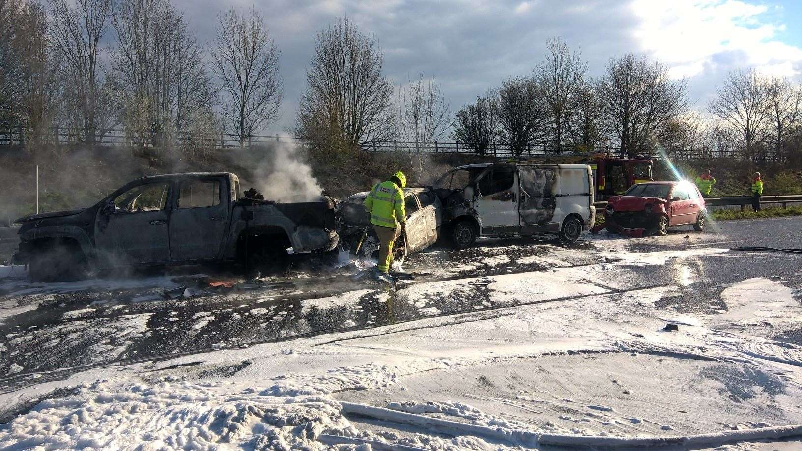 Fire crews put out the flames which destroyed three cars on the M2 near Faversham. Picture: Kent Fire and Rescue Service (8282521)