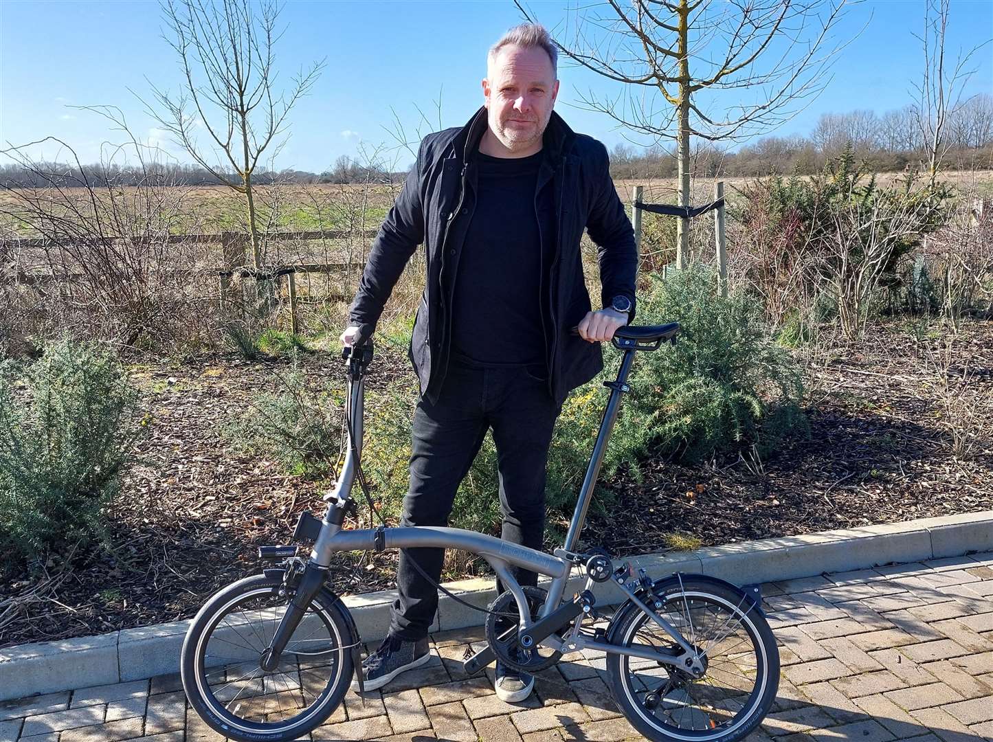 Guy Hollaway with a Brompton bike on the site of the proposed factory in Ashford