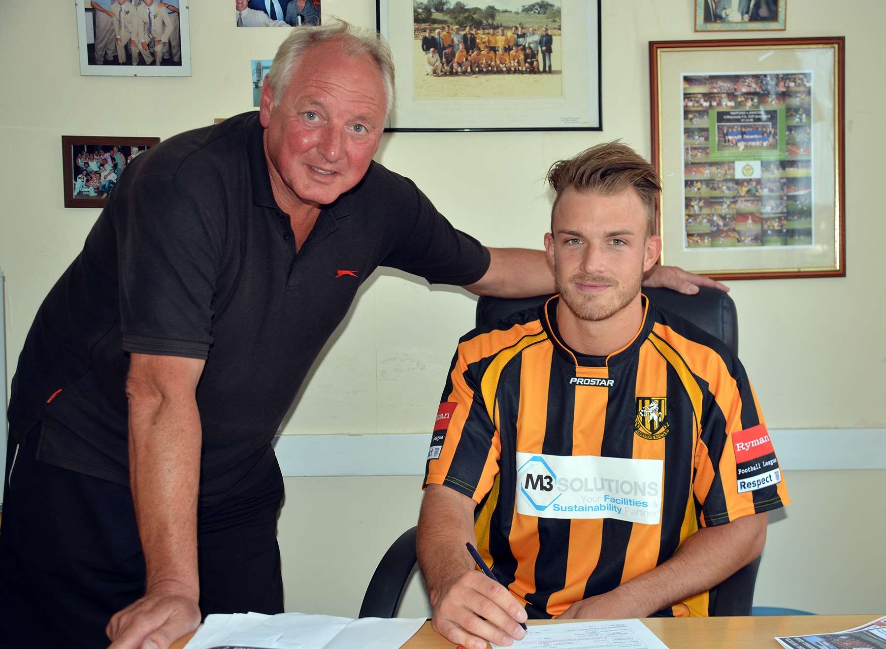 Jon Pilbeam signs his contract alongside Folkestone manager Neil Cugley Picture: Don Linkin