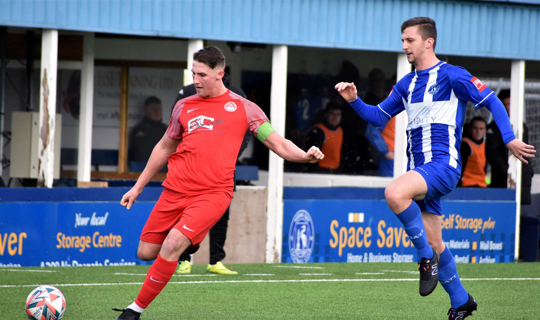 Herne Bay's Kane Rowland closing down Hythe captain Liam Smith. Picture: Randolph File