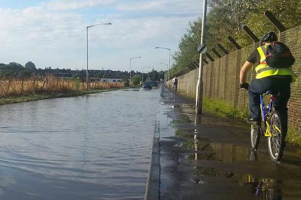 A cyclist avoids the flooded area in Whiteways Road, Queenborough
