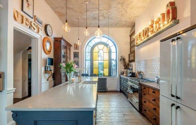 The kitchen has a stained glass window, breakfast bar and top appliances. Picture: Strutt and Parker