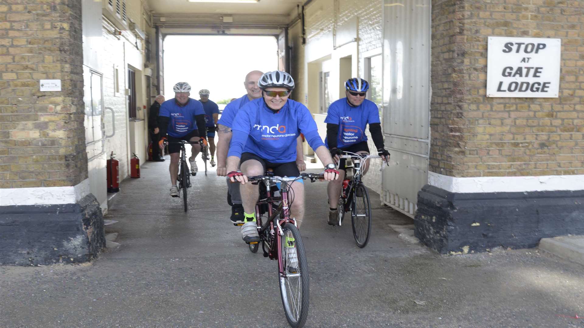 The cyclists return through the old gatehouse at Rochester Prison
