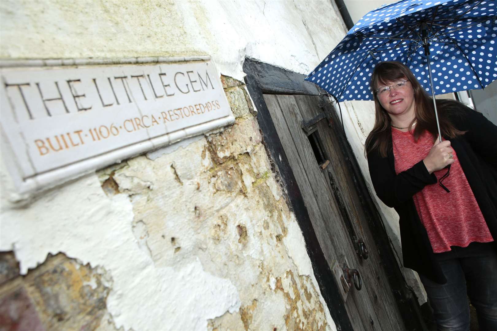 Lin Sharpe outside the Little Gem, with the plaque stating it was built in 1106