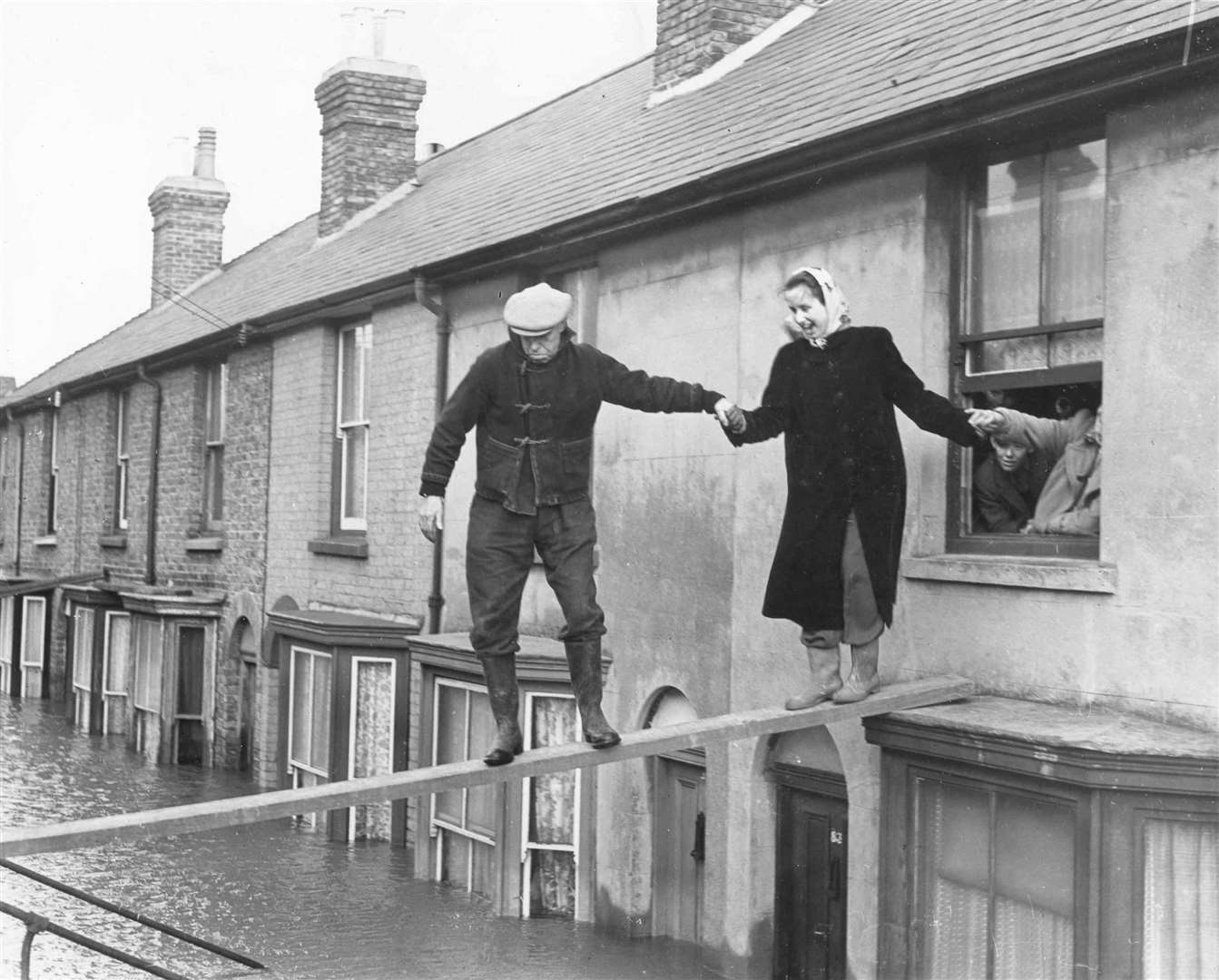 Walking the plank! A woman is rescued from an upstairs room in Island Walk, Whitstable, after horrendous floods hit Kent in 1953