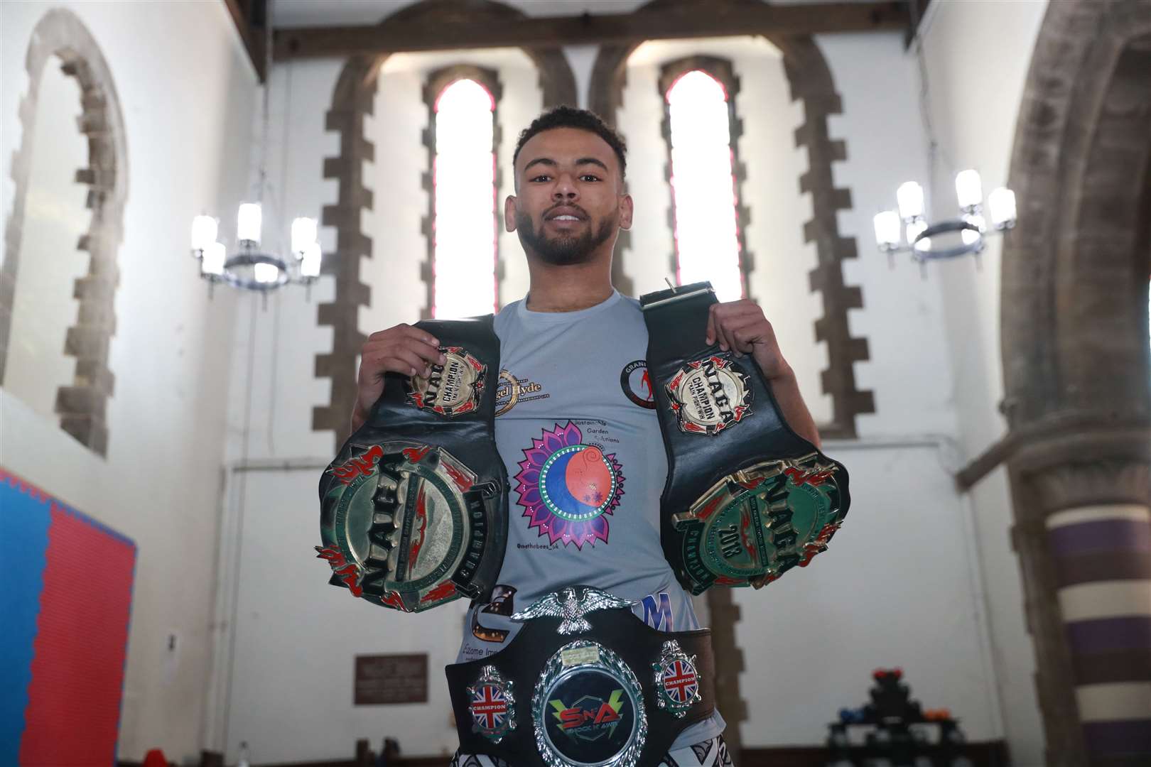 Kayne Isaac shows off three of his MMA belts. Picture: John Westhrop