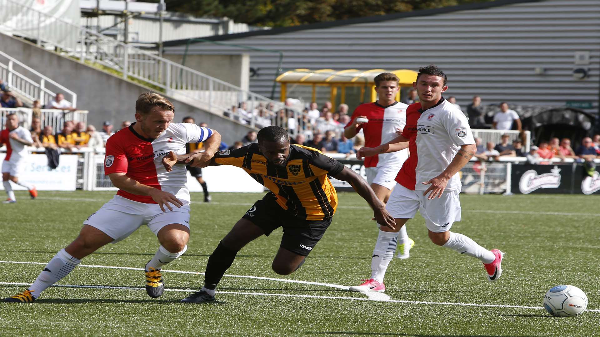 Maidstone's Zavon Hines gets away from Woking captain Chez Isaac. Picture: Andy Jones