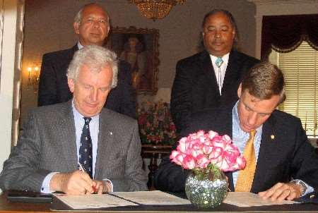 Sir Sandy Bruce-Lockhart (left) and His Excellency Mark R Warner signing the pact. Behind are Native American chiefs Ken Adams (left) and Steve Adkins