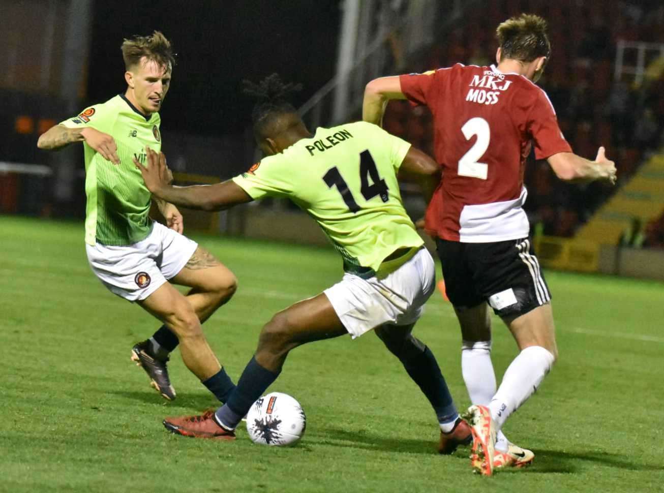 Fleet striker Dominic Poleon twists Woking’s Dan Moss. Picture: Ed Miller/EUFC