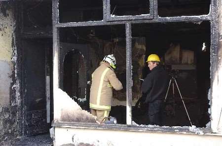 Firefighters looking for clues to the cause of the blaze. Picture: JIM RANTELL