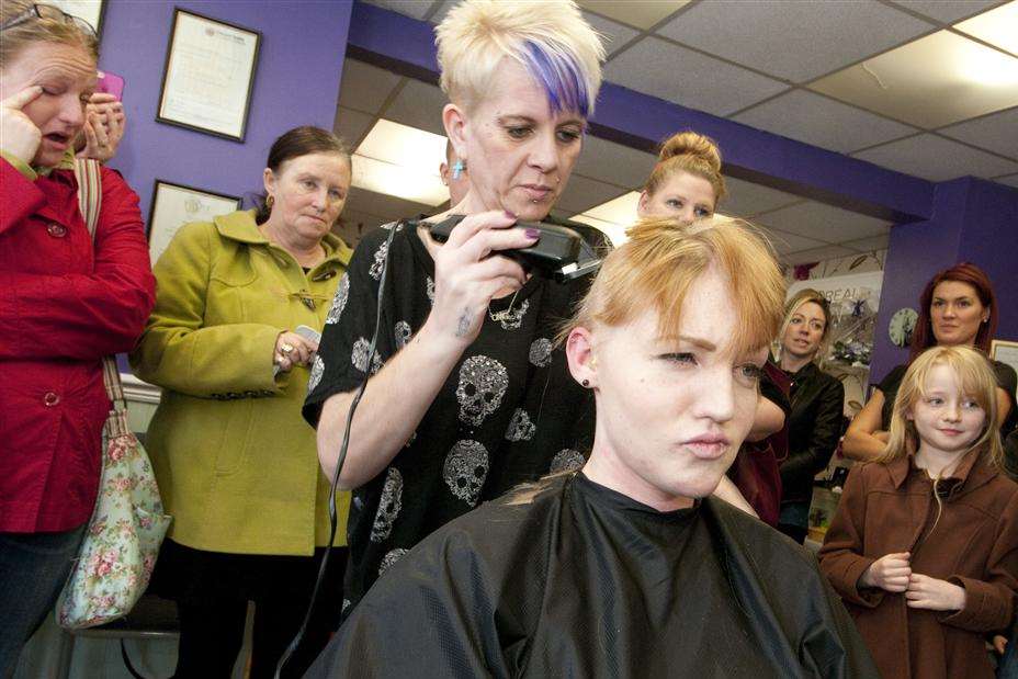 Part way through the head shave by hairdresser Karen Packer, Kirsten Johnson doesn't look too impressed