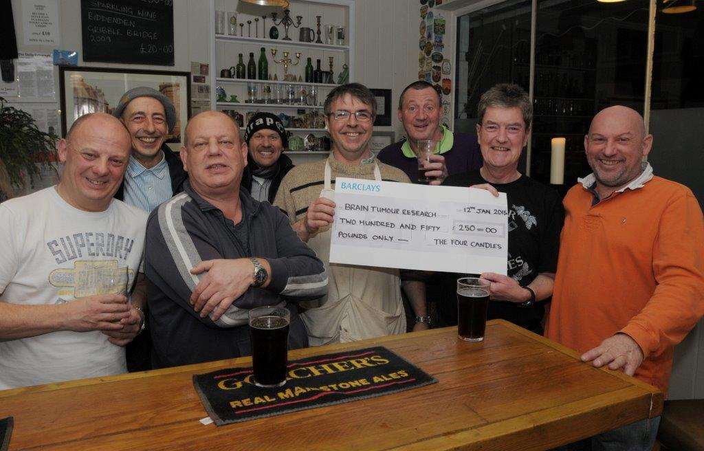 Landlord Mike Beaumont (third left) hands the cheque for Brain Tumour Research to Paul Taylor (second right) at The Four Candles