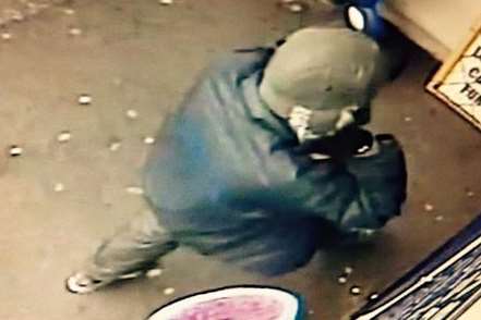 The image captures one of the suspected raiders outside the newsagent's