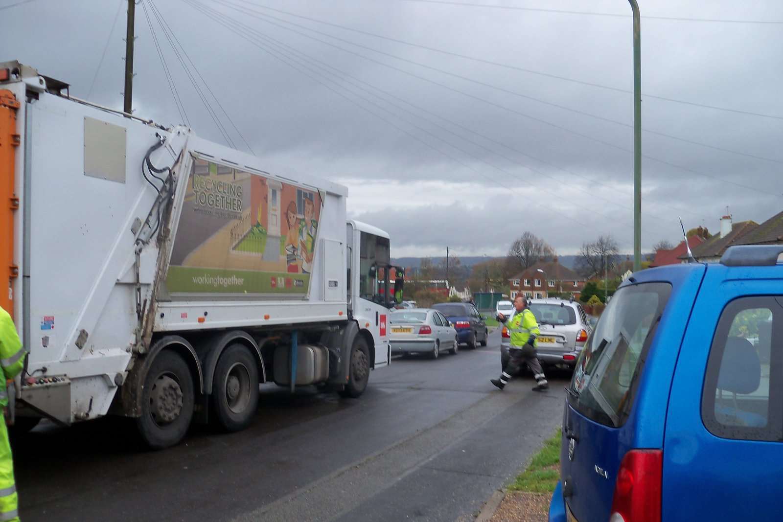 The refuse lorry couldn't pass the parked cars