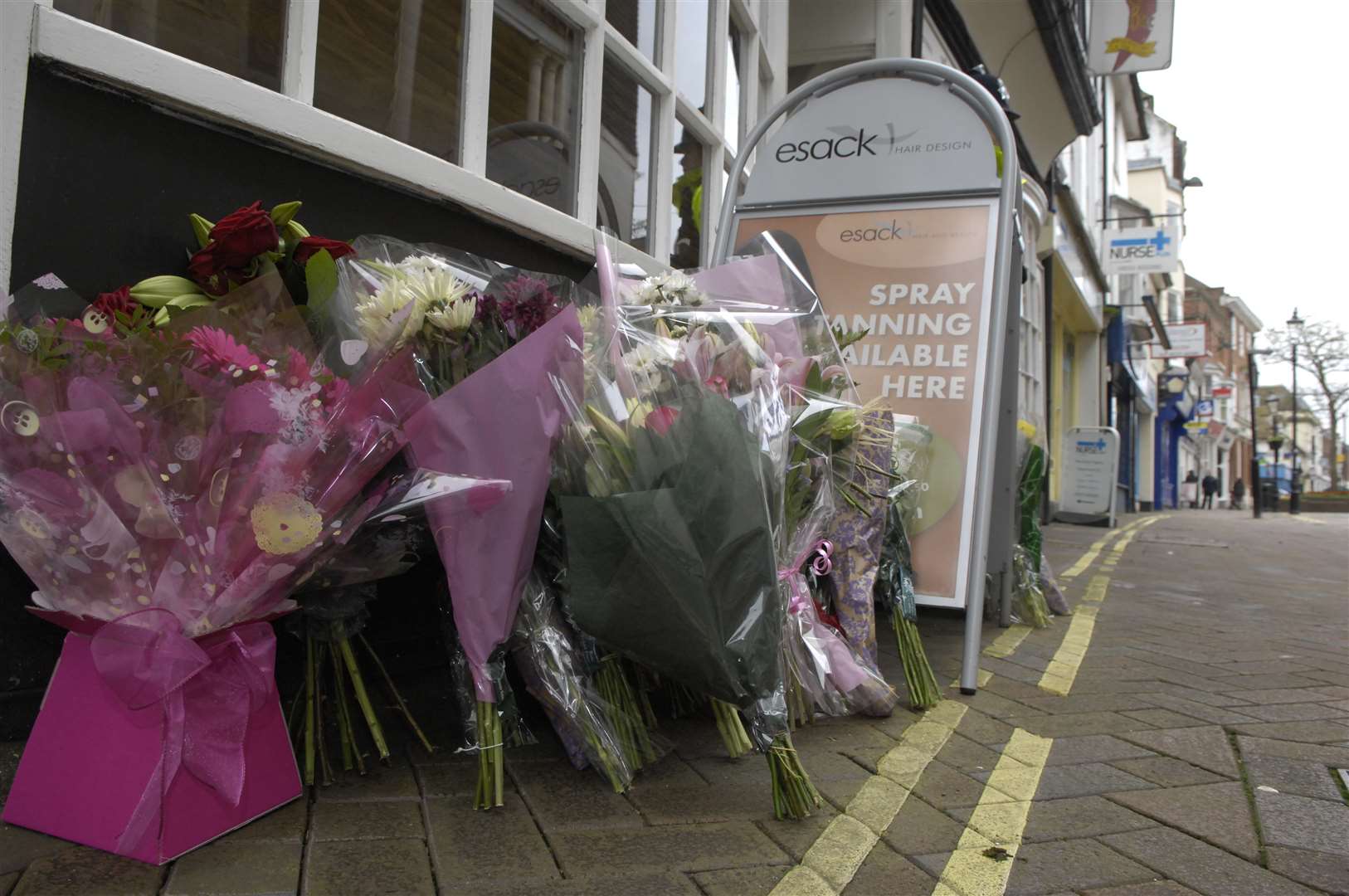 Flowers left at the scene of the stabbing at Esack Hair and Beauty on Ashford High Street Picture: Gary Browne