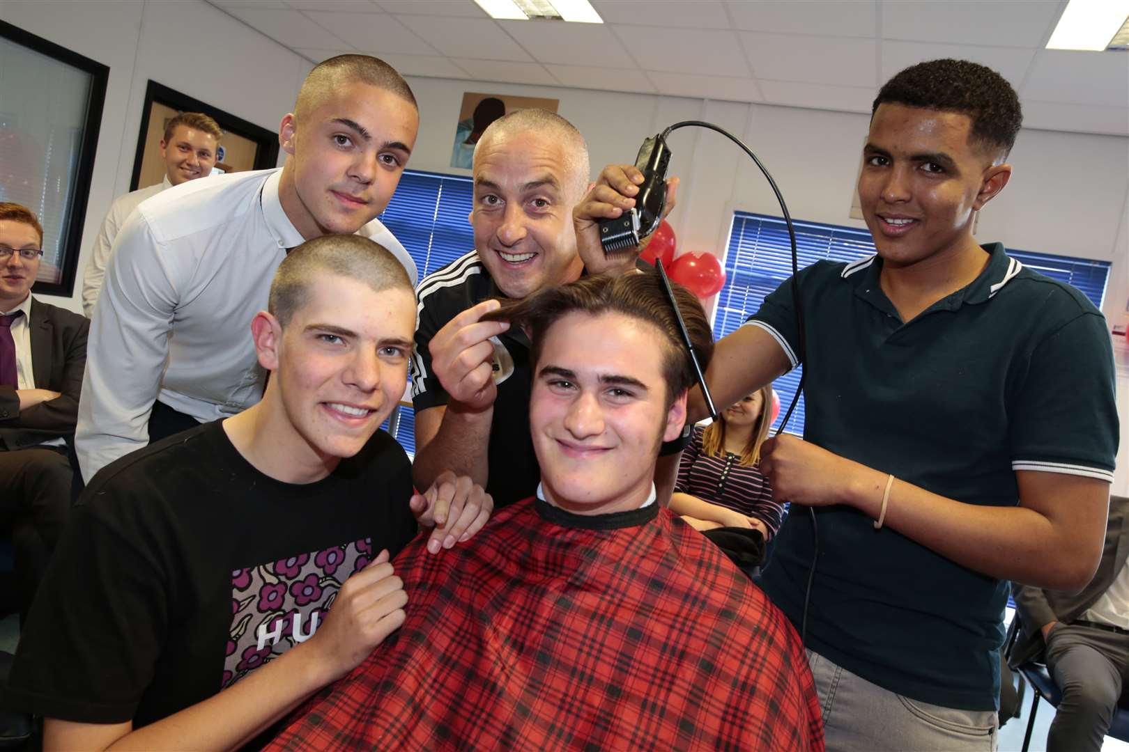 Ben, Ben, teacher Rob Devonald and George have their heads shaved by Harry from Goldscissors. Picture: Martin Apps