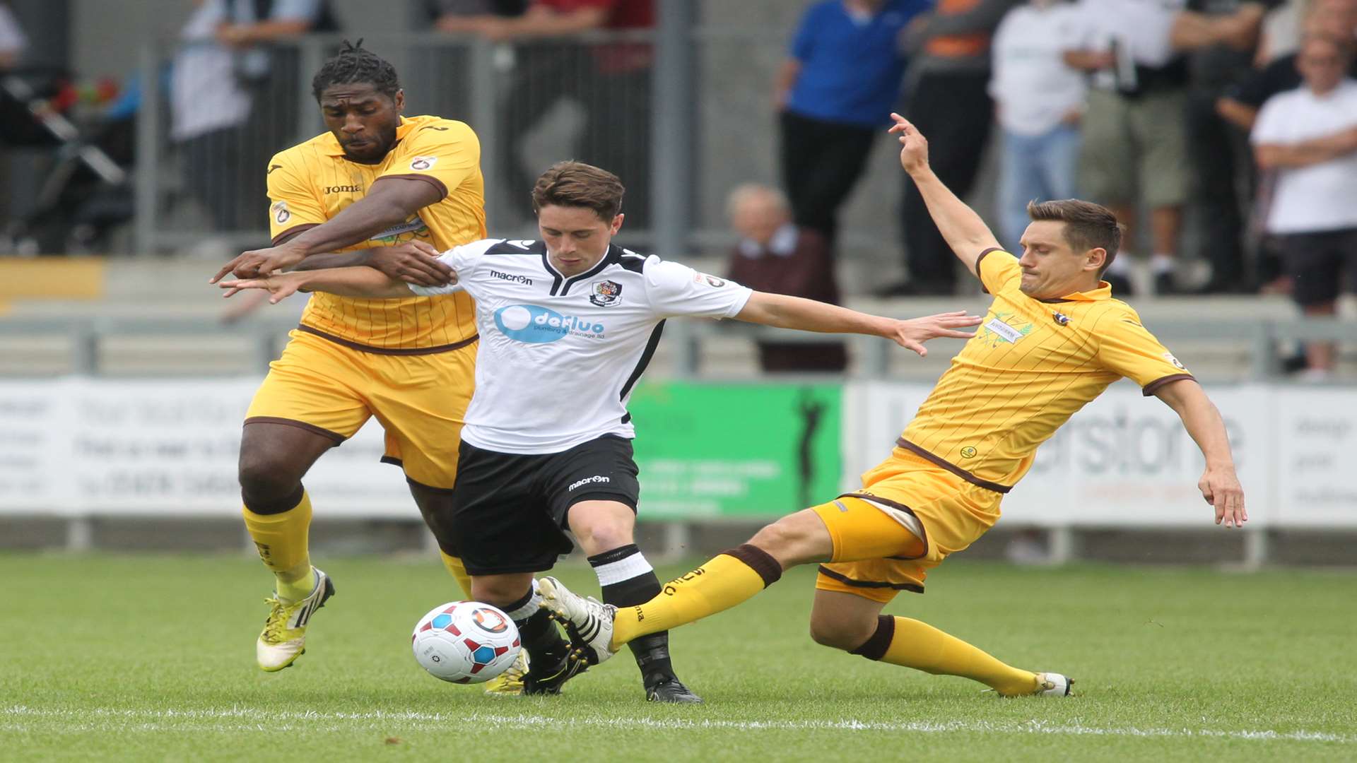 Dartford's Lee Noble gets between two Sutton players Picture: John Westhrop
