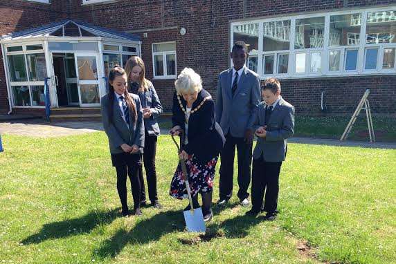 Chairman of DDC, Sue Nicholas with students digging up the first piece of turf to mark the start of construction