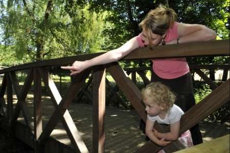 Sharon Bayne points out fish to 3 year-old daughter Beccy from the bridge. Picture: Andy Payton