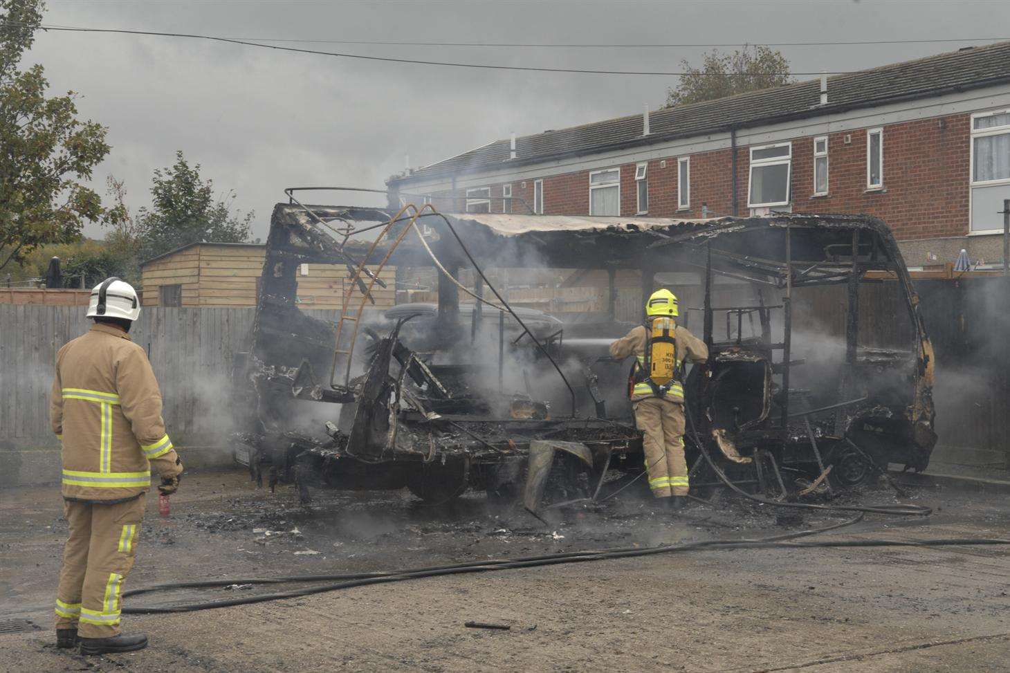Firefighters damp down what is left of the campervan