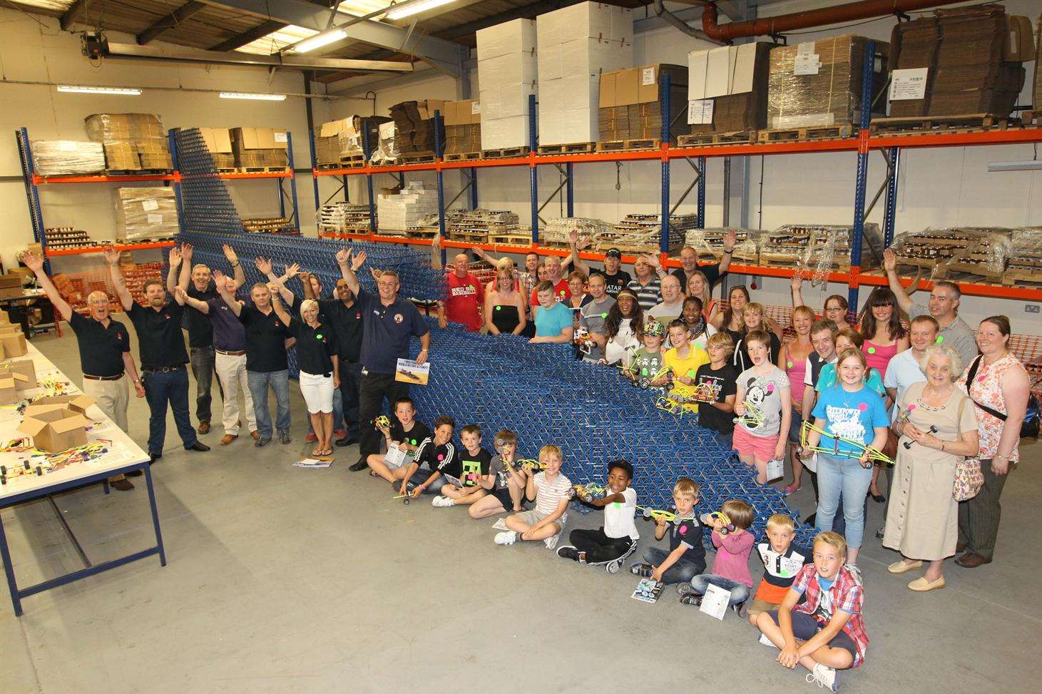 Volunteers and "Bloodhound" pose alongside the partially constructed replica land speed record car that was confirmed as the World's largest K'NEX structure