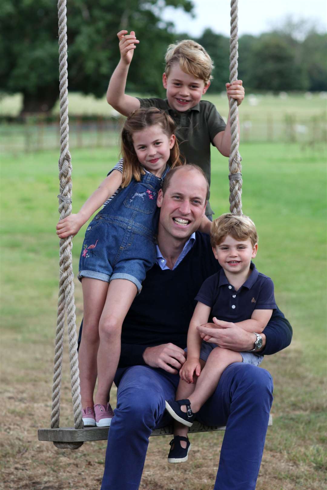 William and his three children pose on a swing (The Duchess of Cambridge/PA)