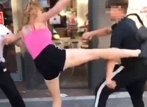 The woman in pink kicked a youngster before she was kicked herself
