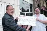 Alan Witherden (left) presents a cheque to Bryn Annis of the Peggy Wood Foundation