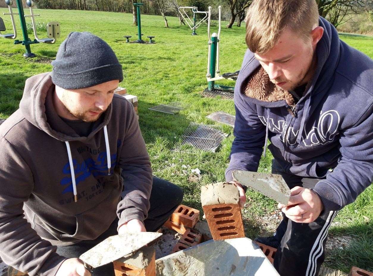 Members also play active roles in the community, as they are seen here building a community barbecue