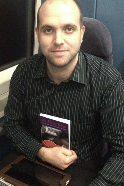 Andy Leaks riding the train with his new book