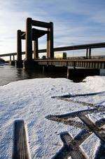 Kingsferry bridge raised, with snow on the banks of the Swale.