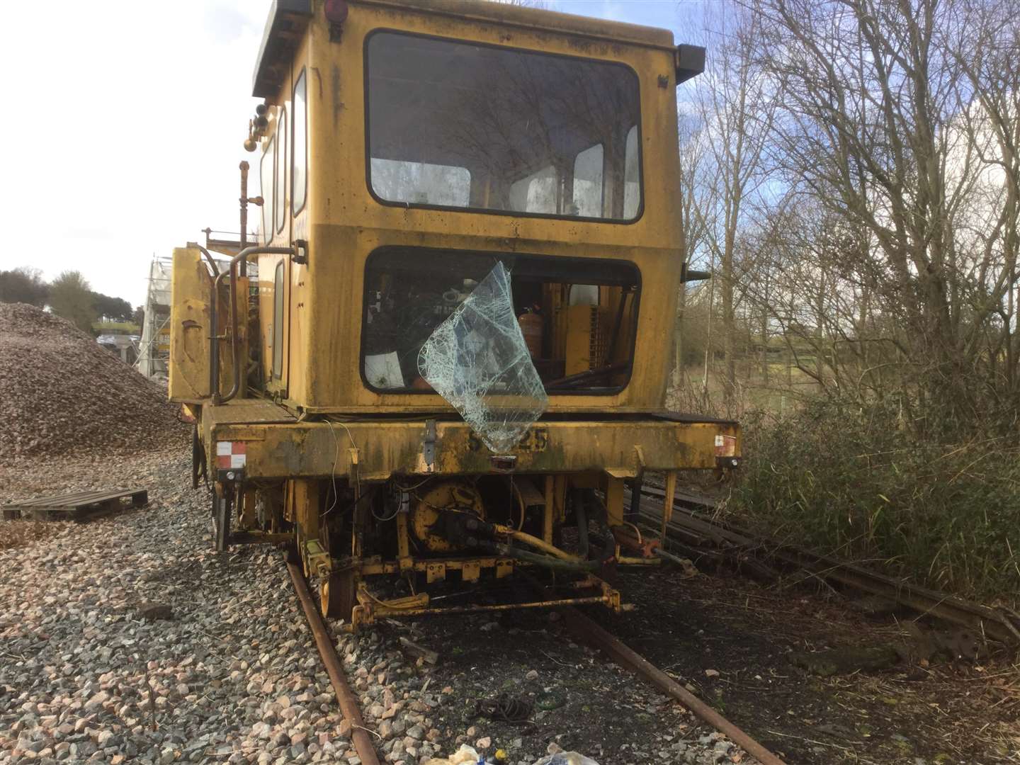 Damage to the tamping machine where glass covered by plastic was smashed to gain entry to the cab above