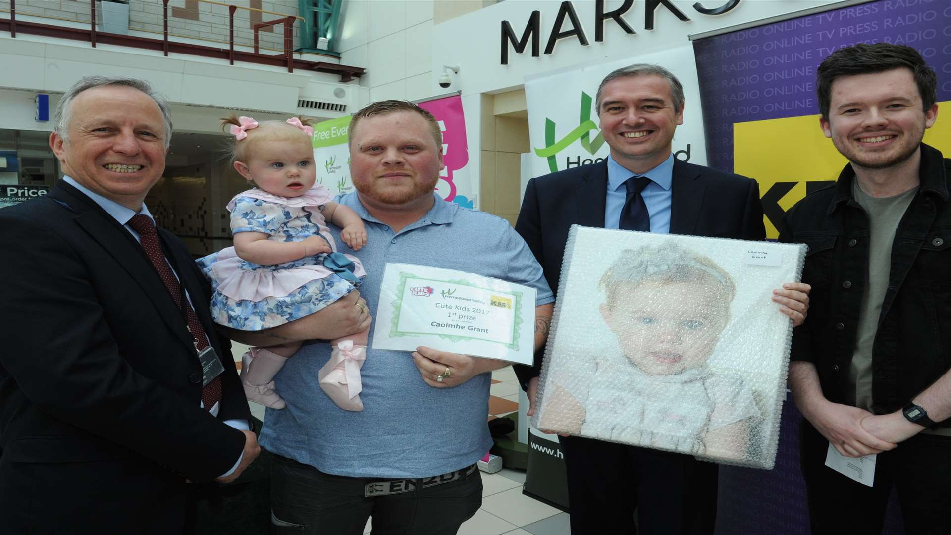 Medway Messenger Cute Kids winners with Glen Scott (kmfm), Matt Ramsden and Mark Rumfitt (centre manager). Caoimhe Grant with James Grant