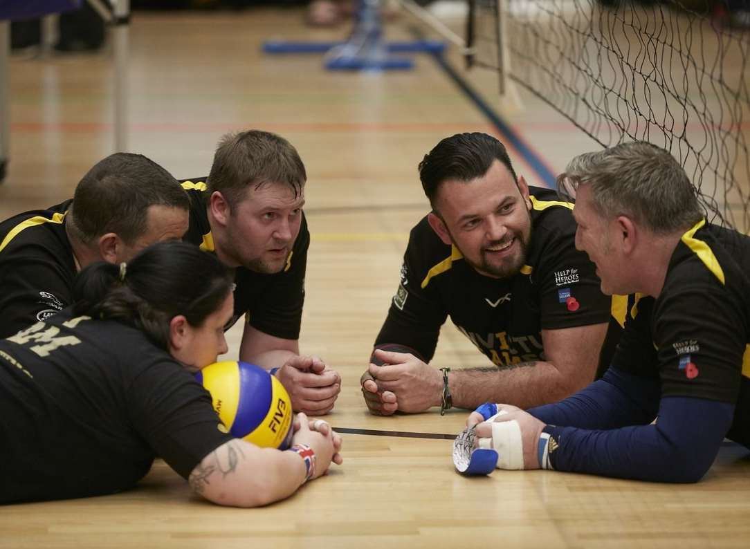 Darren Young, far right, striking the ball during a match and in discussion with teammates