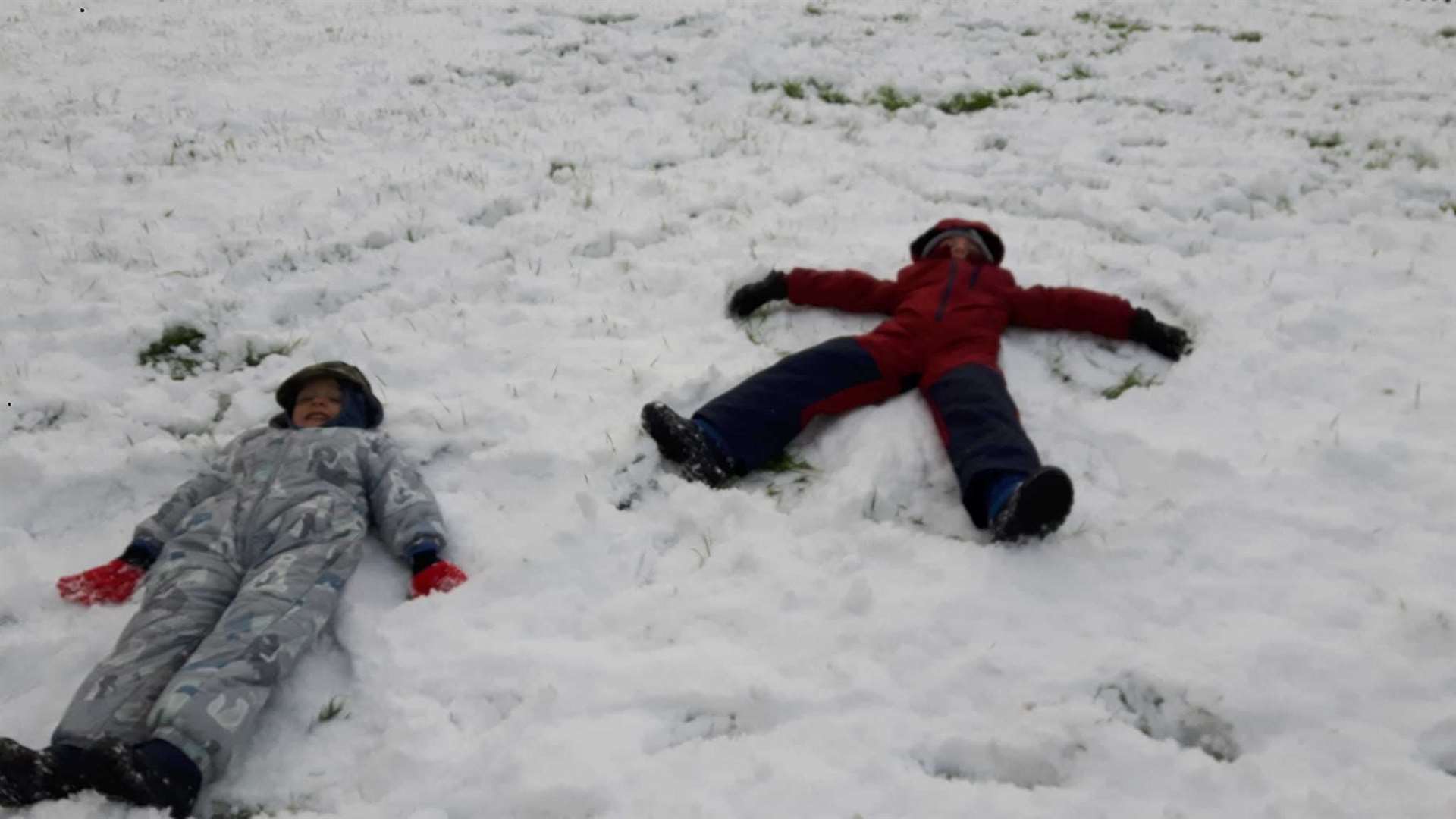 Children enjoying the snow in Rainham . Maxx and Lukas make snow angels