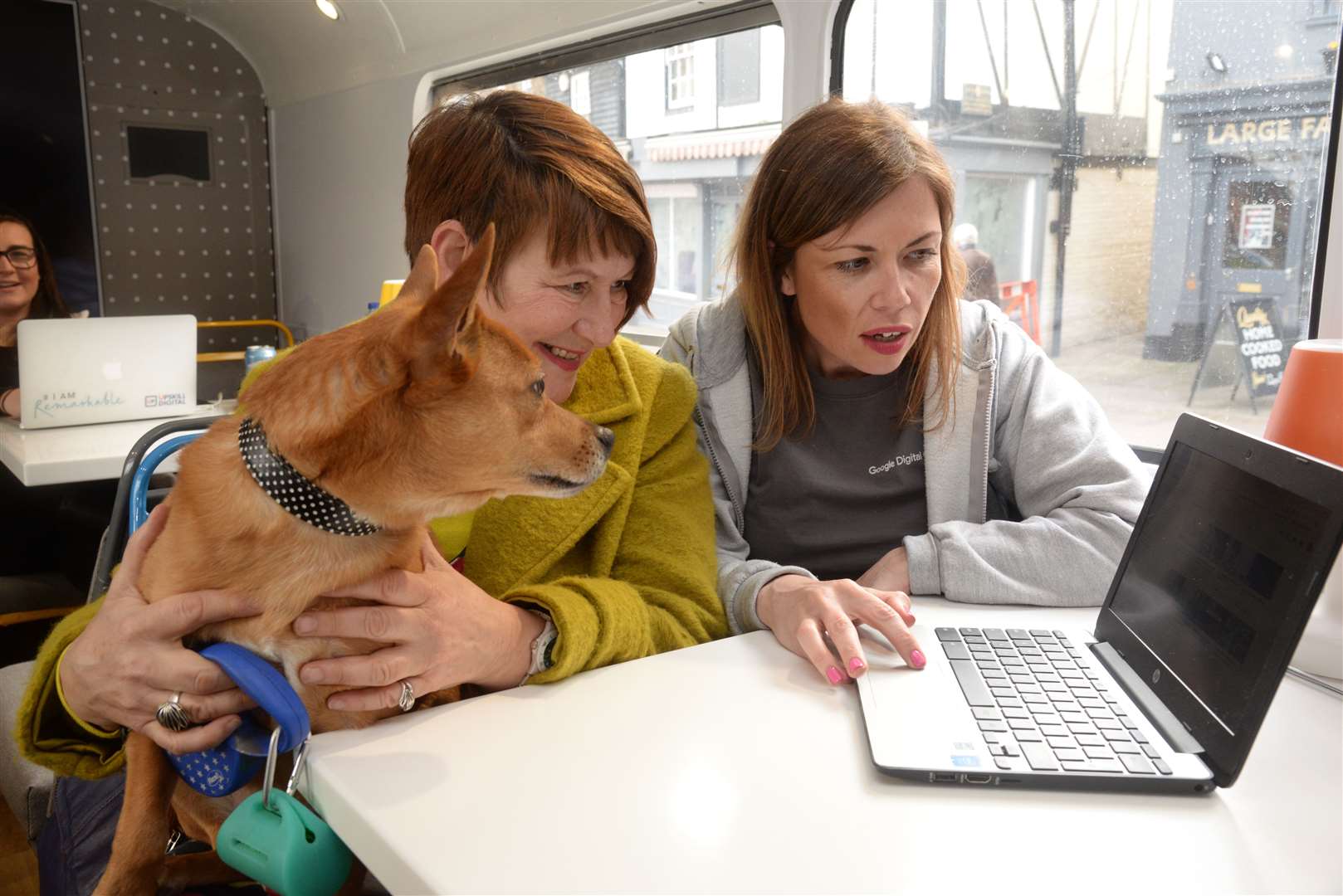 Martine Carruthers and her dog 'Doozey' visit Google Digital Garrage Coach Victoria Mooney in the Google Bus in Rochester on Friday. Picture: Chris Davey. (8021209)