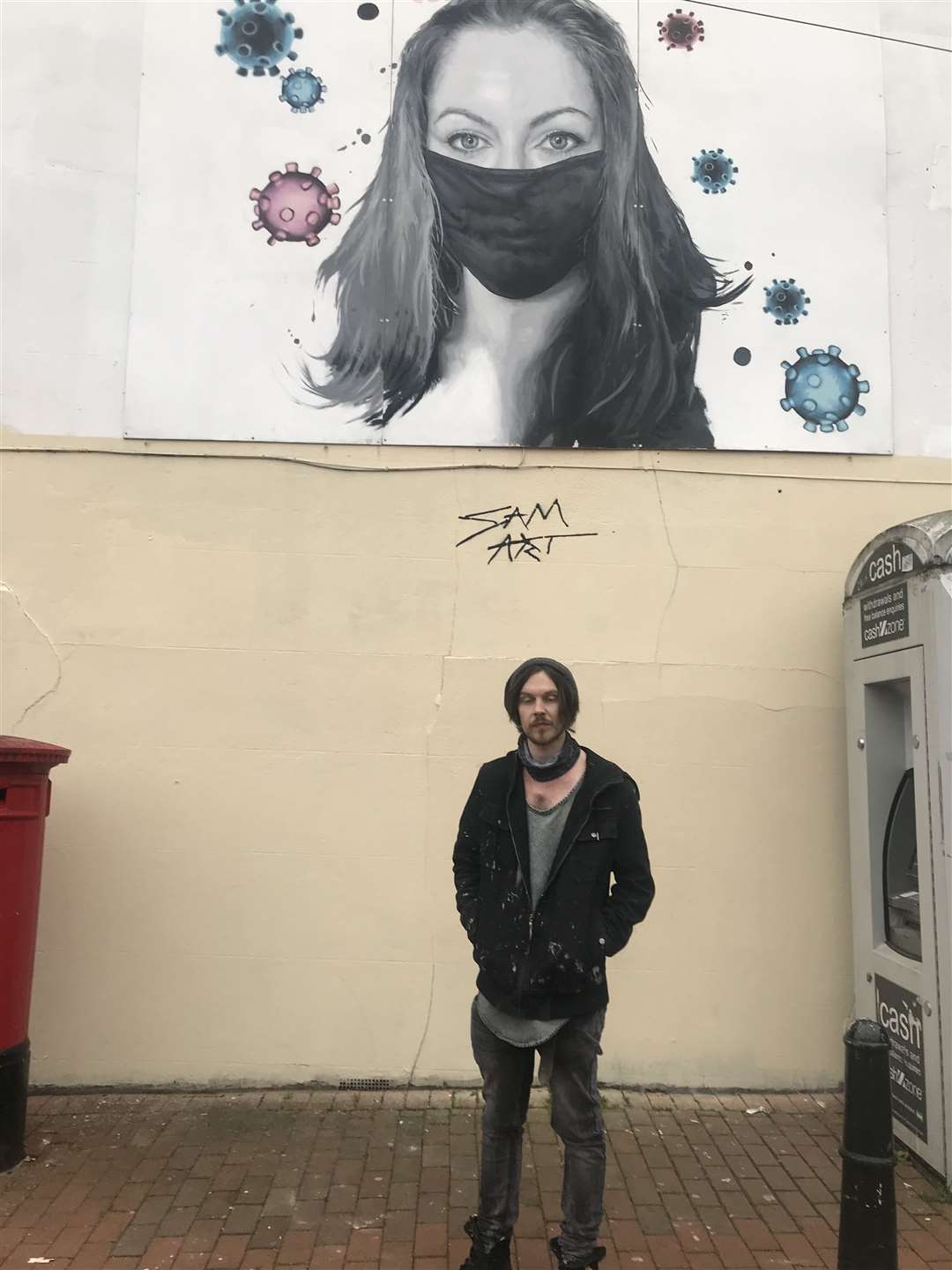 Street artist Sam Collins with his artwork