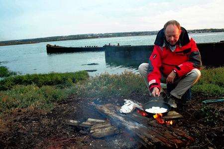 Tour guide Dave Wise cooks dinner on an open fire