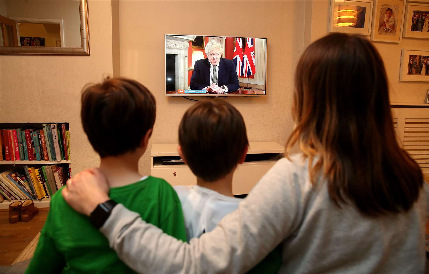 A family in Knutsford, Cheshire, watch Prime Minister Boris Johnson making a televised address (Martin Rickett/PA)