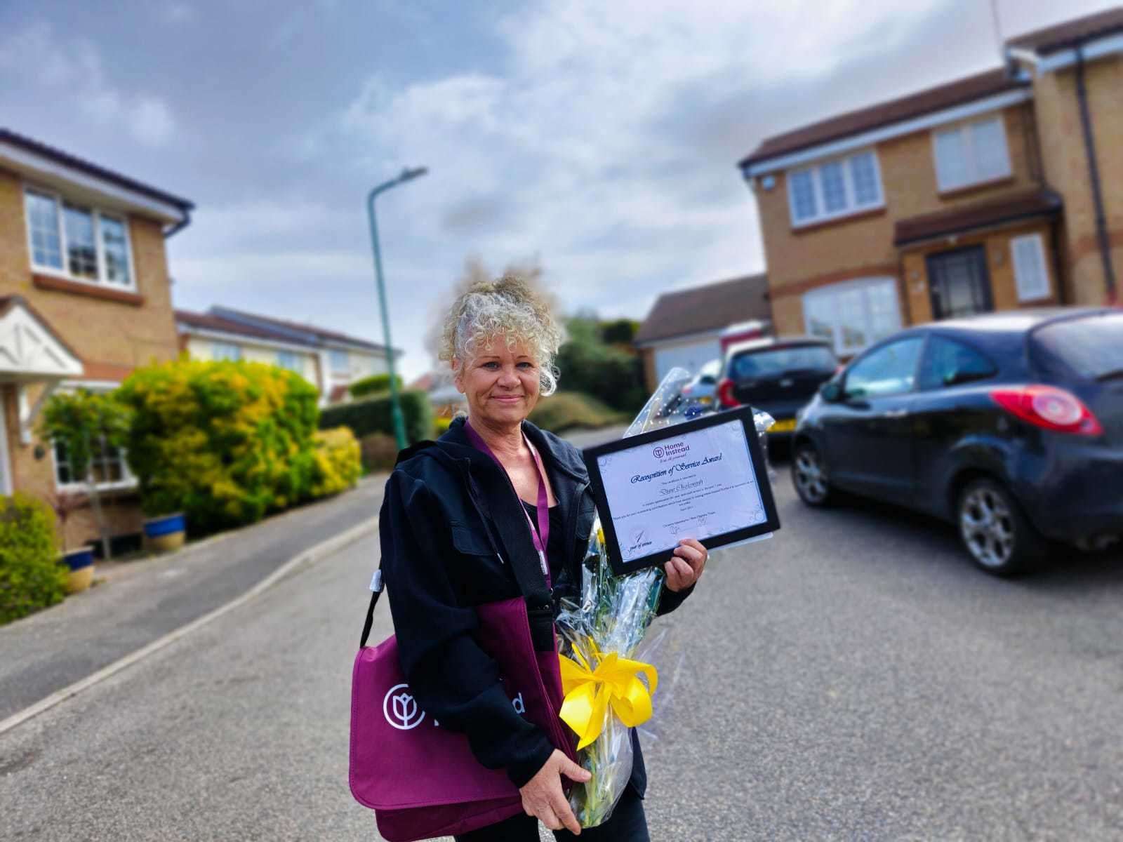 Diane with flowers and certificate for her work. Picture: Home Instead Dartford