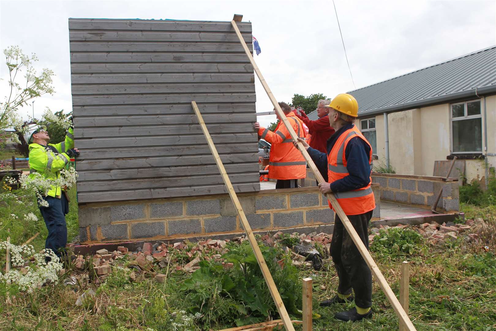 Martin Hawkins, chairman of the Trustees with other volunteers putting up the first panel on an extension to Eastchurch Aviation Museum. Picture: John Westhrop.(11971167)