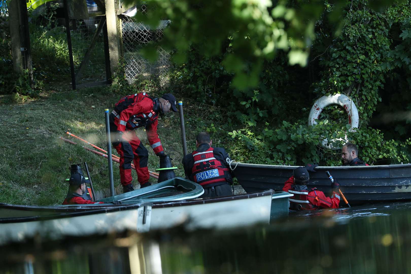 Police forensic officers in waterproof clothing gather evidence in the lake near the boats on the grounds of Lullingstone Castle in Eynsford, Kent (Yui Mok/PA)
